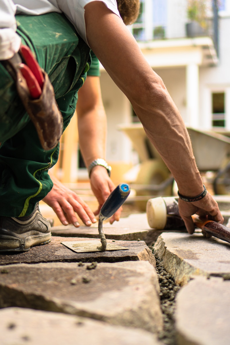 a man working on a piece of concrete, contractors