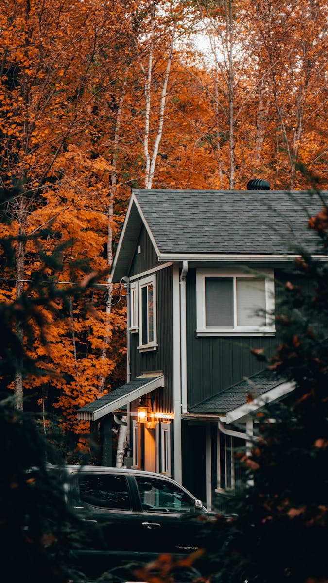 Quaint house with autumnal trees in vibrant fall colors, perfect for seasonal themes. insurance